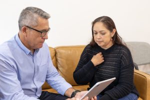 Maori doctor and Australian Aboriginal patient talking in a waiting room